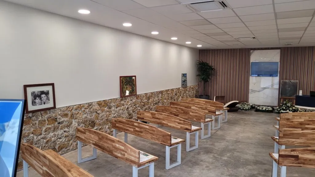 Salle de cérémonie funéraire moderne avec bancs en bois et espace de recueillement