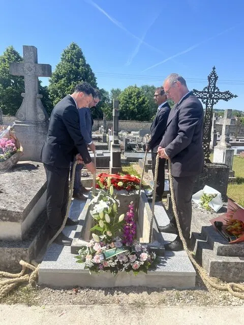 Agents funéraires descendant le cercueil dans le caveau lors de l'inhumation au cimetière
