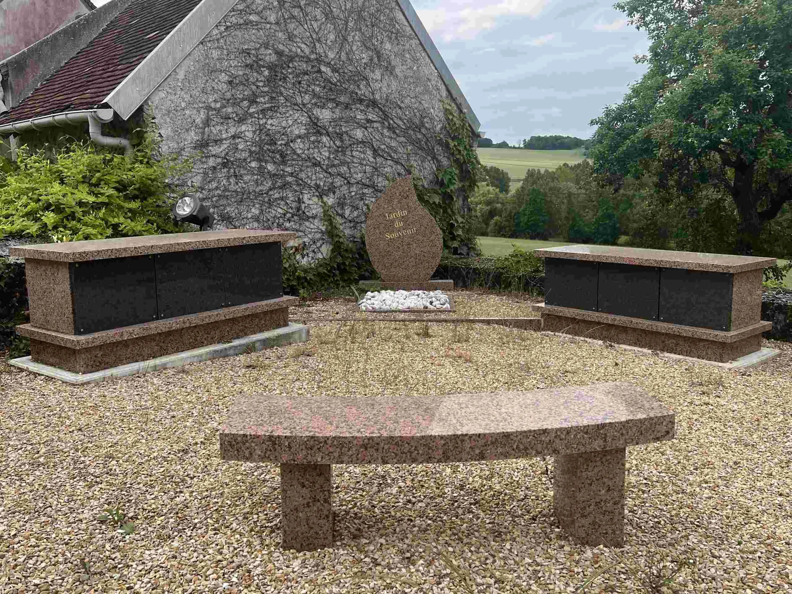 Exposition de monuments funéraires en granit et banc de recueillement