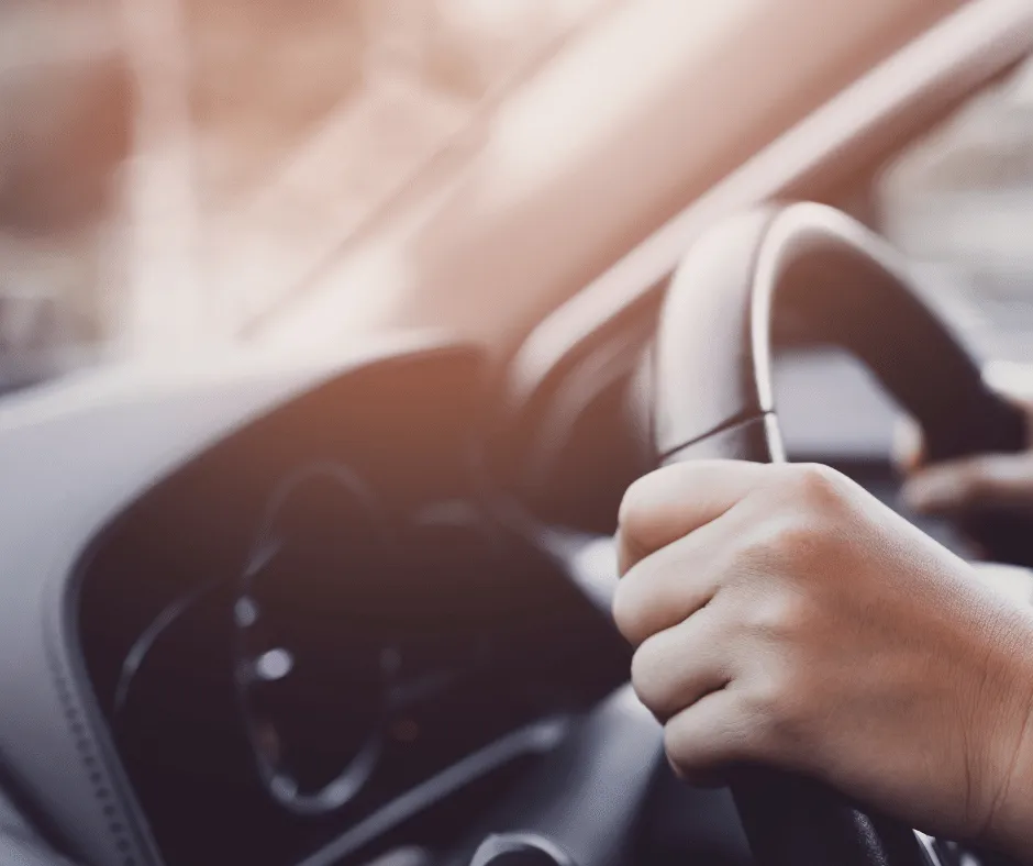 Mains d'un chauffeur tenant le volant d'un véhicule de transport funéraire